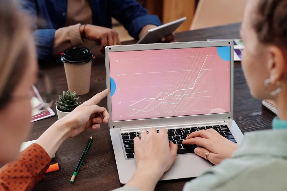 A clean and modern desk setup with a lightbox displaying #TREND and a computer monitor showing a social wall solution.